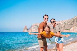 jovem família na praia branca durante as férias de verão foto