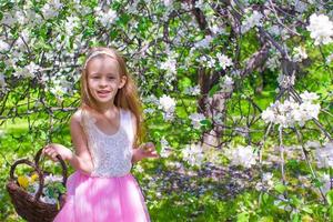 menina adorável feliz no jardim de macieiras em flor foto