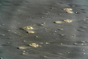 pegadas humanas na areia de uma praia tropical foto