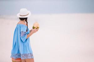 jovem mulher bonita se divertindo na praia tropical. garota feliz andando na praia tropical de areia branca foto