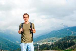 homem turista nas montanhas no fundo do nevoeiro foto