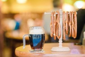 feche pretzels saborosos salgados e cerveja no fundo de madeira. foto