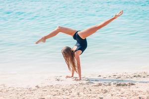 adorável menina se divertir na praia tropical durante as férias foto