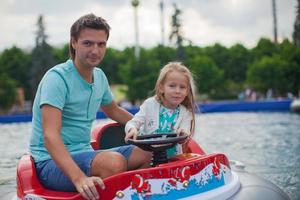jovem pai e sua filhinha andando em um aerobarco na atração foto