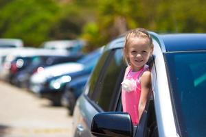 menina adorável no carro olhando para a janela nas férias de verão foto