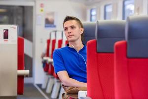 jovem feliz viajando de trem foto