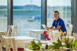 jovem trabalhando com laptop no aeroporto café w foto