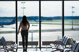 silhueta de passageiro de avião em um saguão de aeroporto esperando aeronaves de voo foto