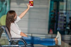 mulher feliz com pequeno modelo de avião e passaportes no aeroporto foto