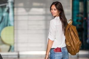 mulher jovem feliz com passagem aérea e passaportes no aeroporto à espera de embarque foto