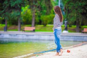 jovem mulher feliz andando perto do lago no dia quente de outono foto