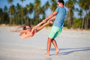 menina e pai durante as férias na praia tropical foto