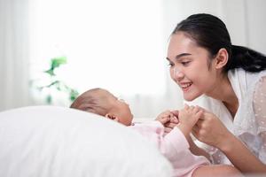 parentalidade da mãe e vida de nascimento do recém-nascido. mãe e filho brincando no quarto ensolarado, família se divertindo juntos. puericultura, conceito de maternidade. foto