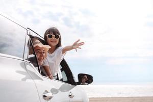 garotinhas felizes viajando de carro desfrutam de férias e relaxamento. viagem de carro hatchback dirigindo viagem de férias de verão em família no carro ao pôr do sol, juntos obter a atmosfera ir para o destino