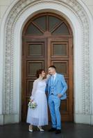 noiva em um vestido de noiva claro para o noivo em um terno azul foto