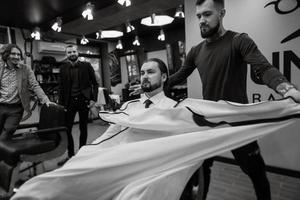 homem barbudo cortando a barba na barbearia foto