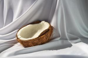 conceito de frutas tropicais, metades de coco branco fresco em fundo de tecido branco foto