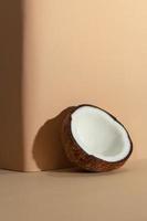 conceito de frutas tropicais, metades de coco branco fresco sobre fundo de cor creme foto