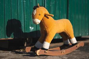 cavalo de madeira de brinquedo infantil deixado sozinho na rua foto