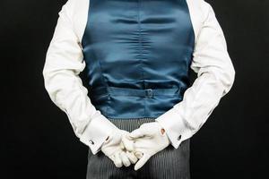retrato de mordomo ou garçom em colete ou colete e luvas brancas de mãos dadas nas costas. indústria de serviços e hospitalidade profissional. foto
