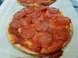 pizza de pepperoni pequena com fatias de carne de salame foto