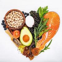 forma de coração do conceito de dieta cetogênica com baixo teor de carboidratos. ingredientes para seleção de alimentos saudáveis em fundo branco de madeira. foto
