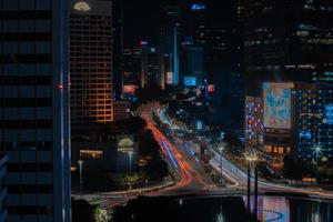 paisagem urbana noturna e semáforo da rodovia em efeito de movimento do obturador de baixa velocidade e ruído. Jacarta, Indonésia, 9 de janeiro de 2023 foto