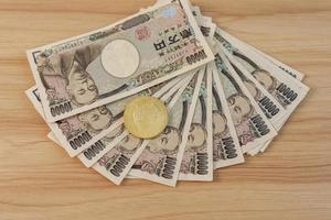 Nota de iene japonês com criptomoeda de ouro dogecoin na mesa. dinheiro do japão, imposto, economia de recessão, inflação, criptografia, investimento e conceitos financeiros descentralizados foto