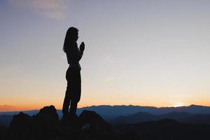 silhueta de jovem religiosa orando a Deus pela manhã, espiritualidade e religião, conceitos religiosos foto
