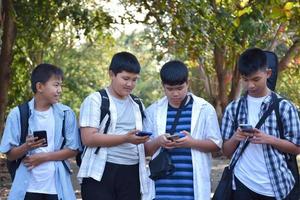 foco suave jovens adolescentes asiáticos mostrando seus próprios telefones celulares para seus amigos durante a caminhada de volta para casa depois de fazer aulas de música e fazer trabalhos de projeto escolar na escola juntos.