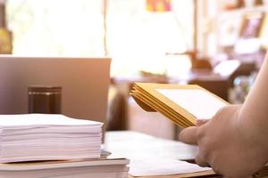 o foco suave do escriturário ou secretário está preparando documentos e envelopes marrons para os interessados em licitar a construção de um grande prédio em um escritório. foto