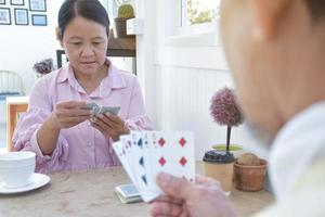 jogo de cartas de idosos em casa em seus tempos livres, recreação e felicidade do conceito de idosos. foto