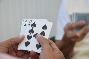 jogo de cartas de idosos em casa em seus tempos livres, recreação e felicidade do conceito de idosos. foto