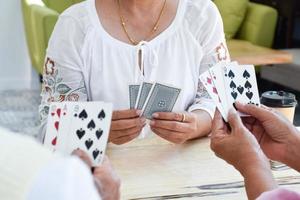 jogo de cartas de idosos em casa em seus tempos livres, recreação e felicidade do conceito de idosos. foto