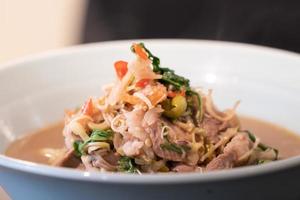 feche o menu tailandês de porco cozido e frito com pasta de camarão em uma tigela branca que está pronta para servir e comer. foto