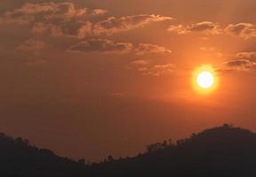 o sol no céu laranja da manhã e a vista da montanha foto