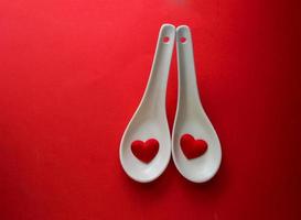 duas formas de coração vermelho em colher branca, saúde do coração e comida, jantar romântico foto
