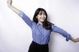 uma jovem mulher asiática com uma expressão de sucesso feliz vestindo camisa azul isolada por fundo branco foto