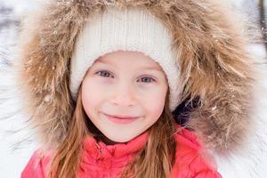 retrato de uma menina adorável na neve ensolarada dia de inverno foto