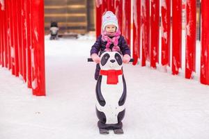 menina feliz patinando na pista de gelo foto