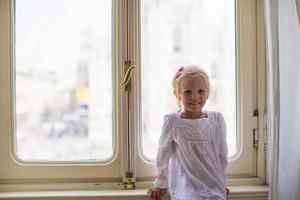 adorável menina olhando pela janela no duomo, milão, itália foto