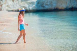 adorável menina ativa na praia durante as férias de verão foto