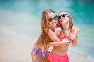 garotinhas engraçadas felizes se divertem muito na praia tropical brincando juntas. foto