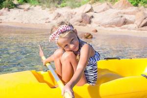 menina adorável gosta de andar de caiaque durante as férias de verão foto