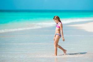 menina adorável na praia durante as férias de verão foto