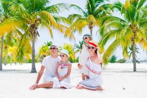 família de quatro pessoas na praia branca foto