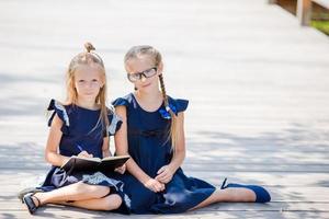 adoráveis meninas da escola com notas e lápis ao ar livre. de volta à escola. foto