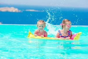 adoráveis meninas brincando na piscina ao ar livre com bela vista foto