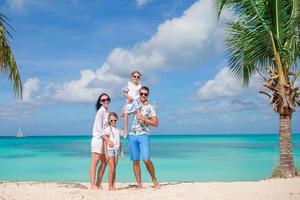 família linda feliz com crianças na praia foto