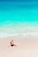 jovem mulher aproveitando o banho de sol no oceano turquesa perfeito foto